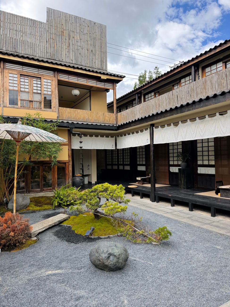 A serene minimalist courtyard with cedar timber and smooth river stones